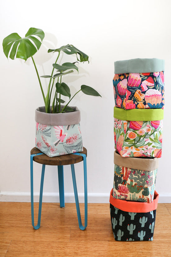 stack of multi-coloured square fabric planters with monstera plant
