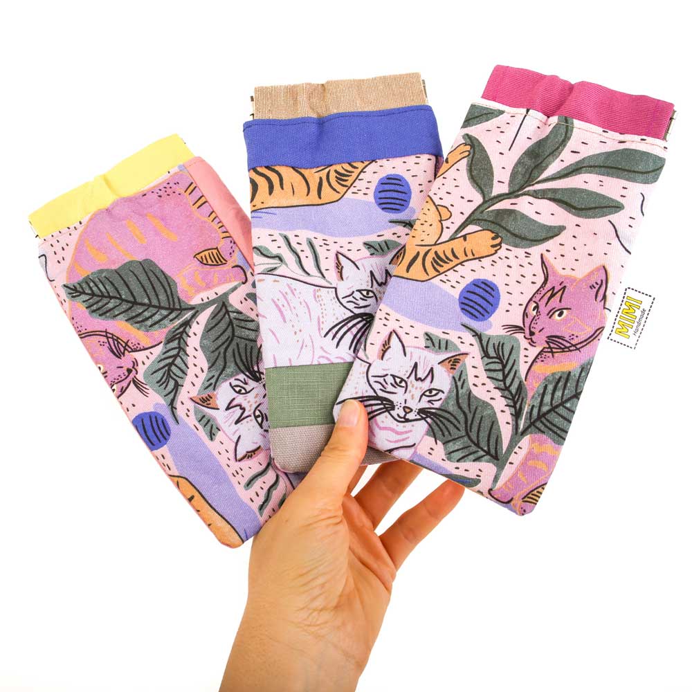 Colourful cat-themed glasses pouches held by a hand on a white background