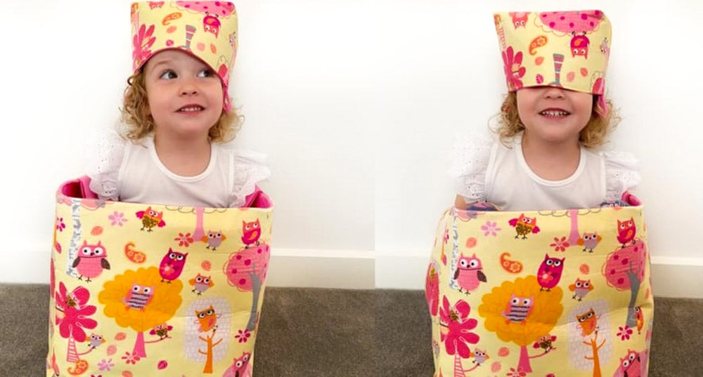 little girl inside a large toy storage basket with a smaller basket on her head MIMI Handmade Baskets