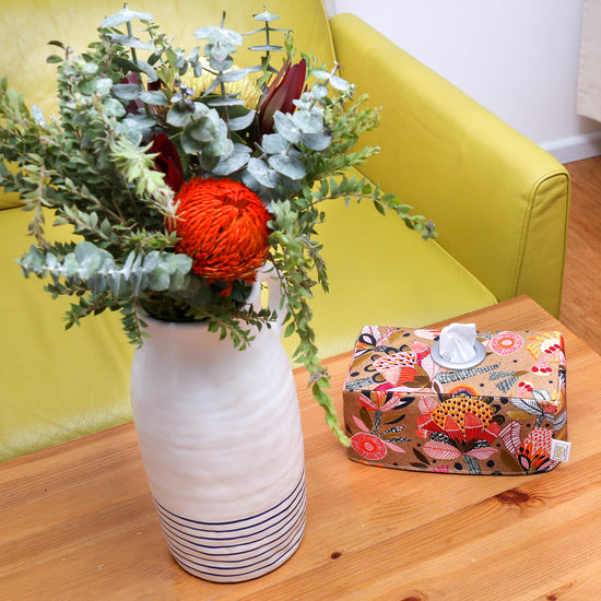 native-flowers-rectangular-cotton-tissue-box-cover-placed-on-a-coffee-table-next-protea-and-eucalyptus-leaves-bouquet-in-front-of-yellow-sofa