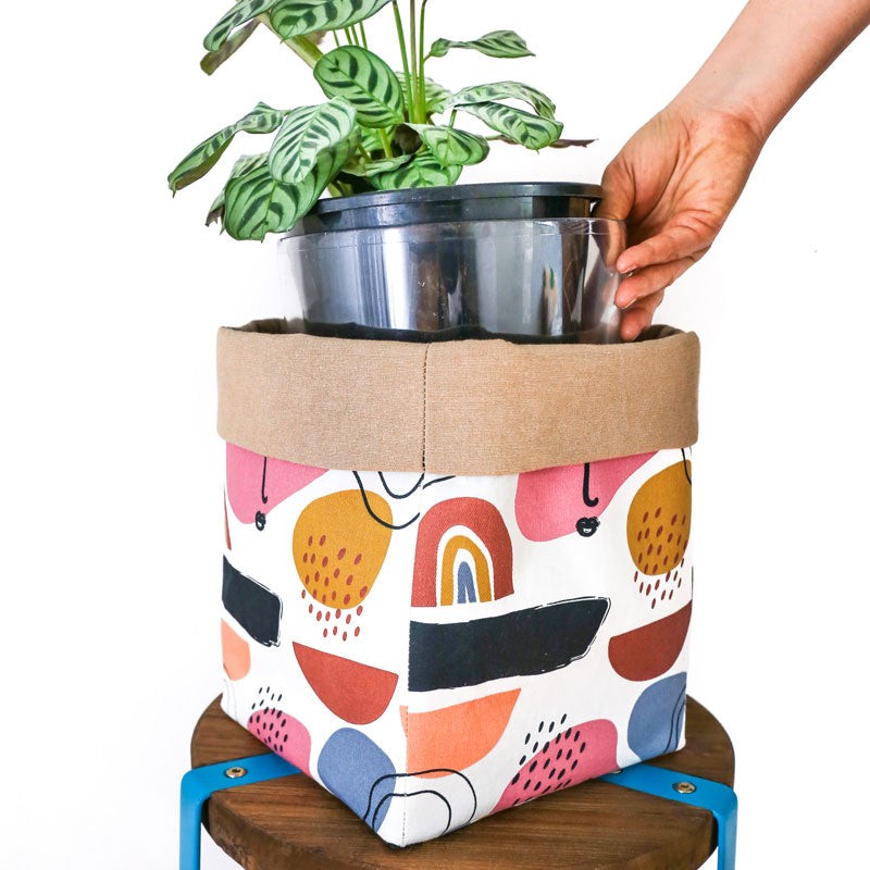 Load image into Gallery viewer, boho-muted-rainbow-plant-pot-cover-with-house-plant-in-a-clear-pot
