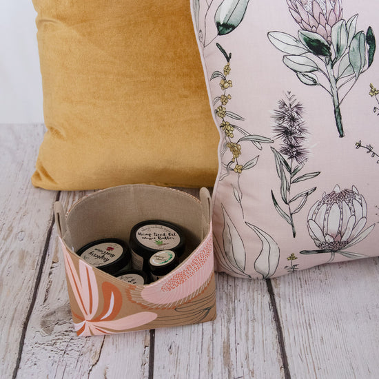 botanical-terracotta-tones,-mustard-and-dust-pink-cushions-and-decorative-basket-with-cosmetics