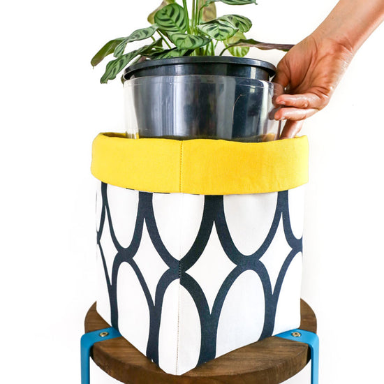 modern-yellow-white-and-black-geometric-plant-pot-cover-with-house-plant-in-a-clear-pot