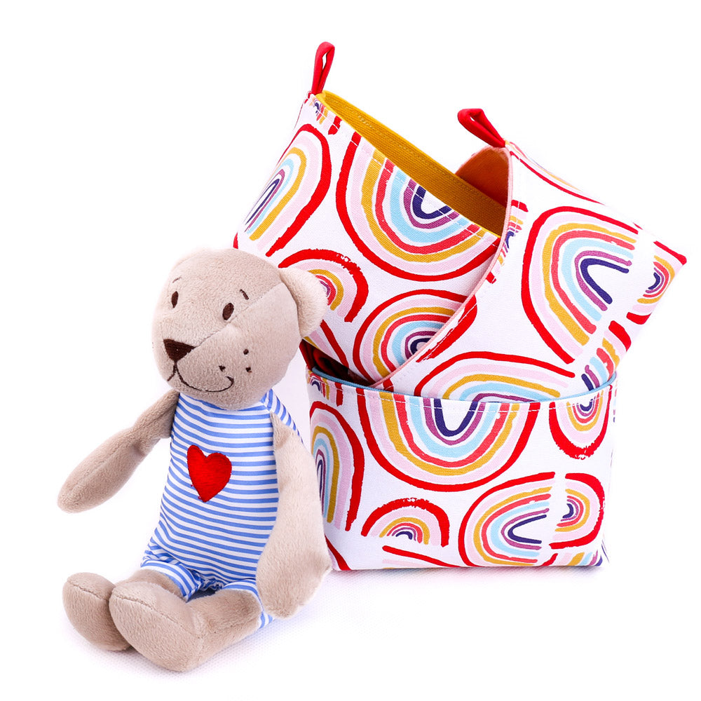 soft teddy bear from Ikea in front of 3 happy rainbow handmade fabric storage baskets by MIMI Handmade
