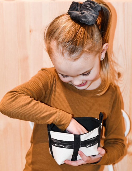 young girl holding a black monochrome grid fabric storage basket, handmade in Australia by MIMI Handmade